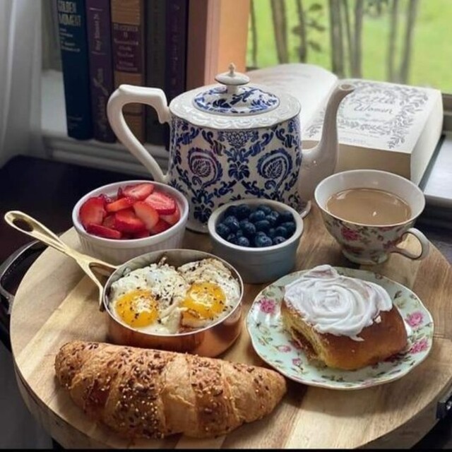 Complete brunch with fried eggs, fruits, pastry and a cup of tea